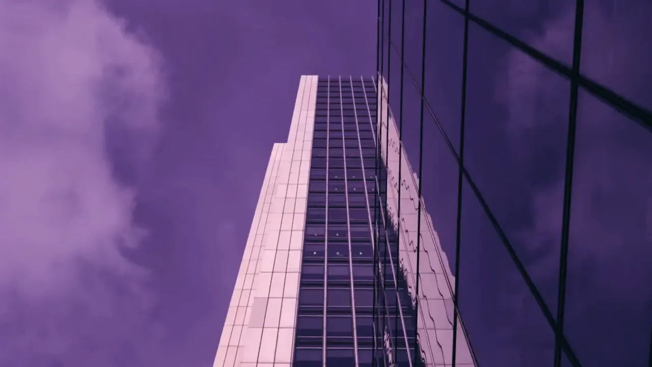Fachada de prédio corporativo vista de baixo, em tons de roxo